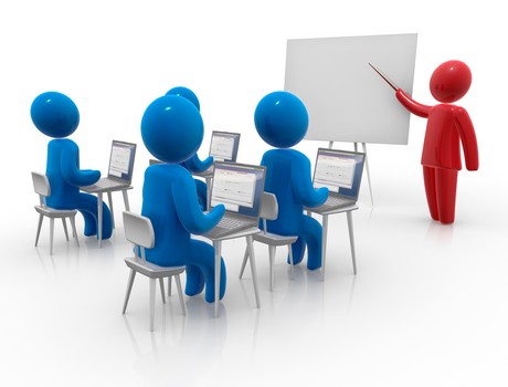 People working on laptops in a classroom, with a presenter at the front